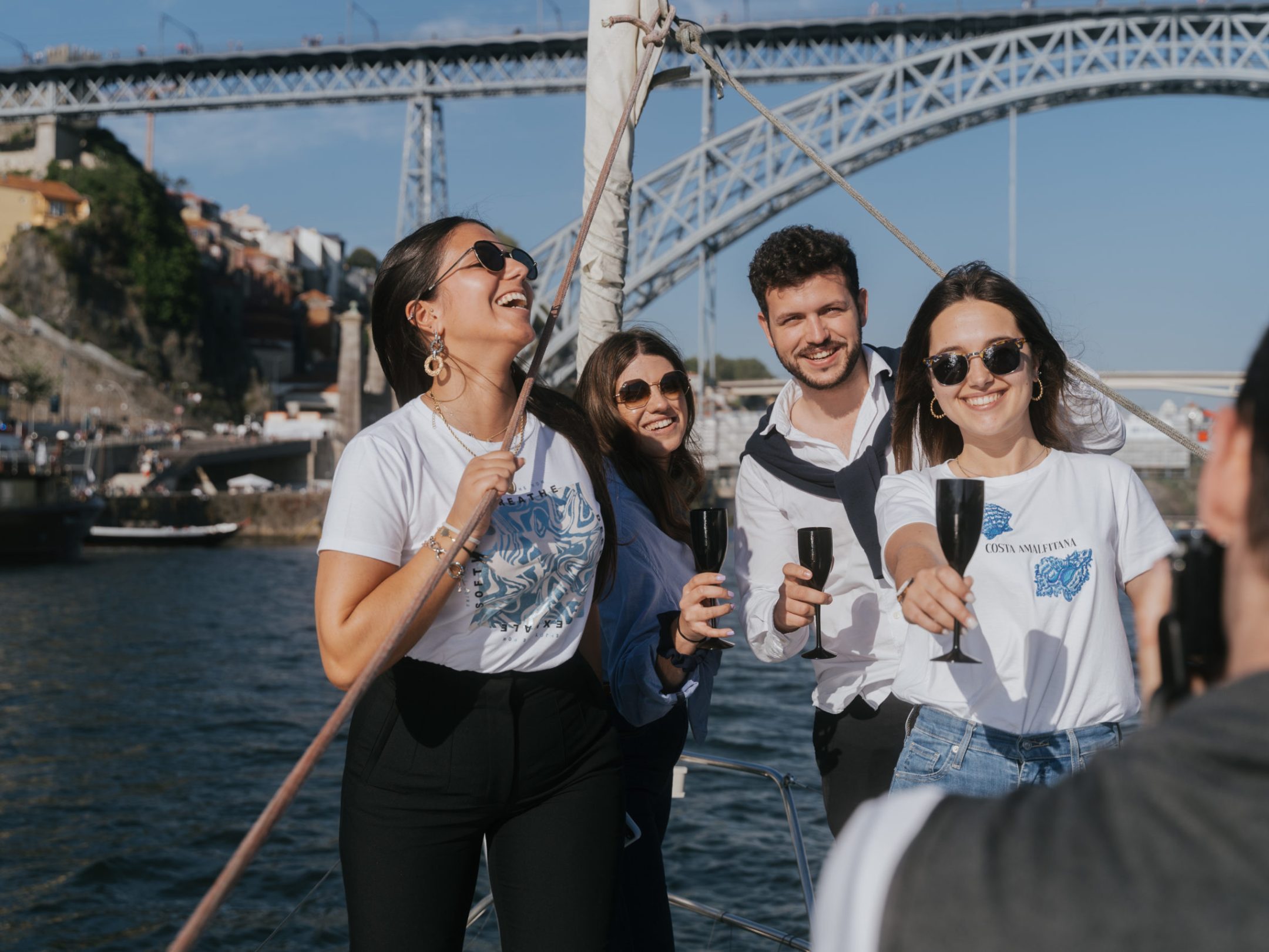 a group of people standing on a bridge over a body of water rio douro sailing 360