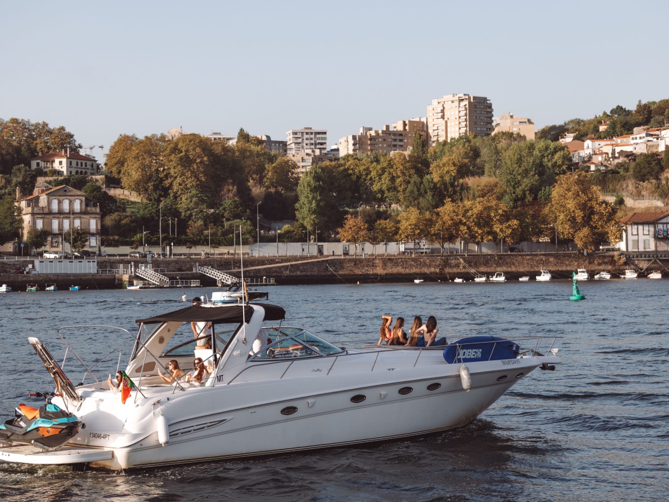 a small boat in a body of water with a city in the background